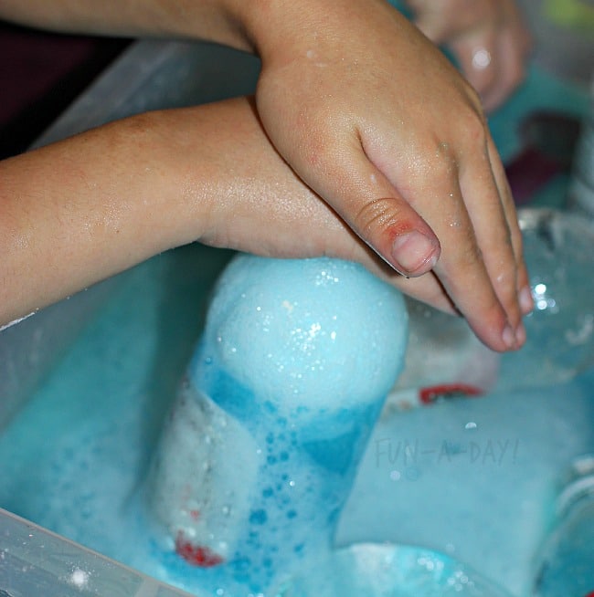 kids' hands playing in bubbly water during a star wars day science experiment